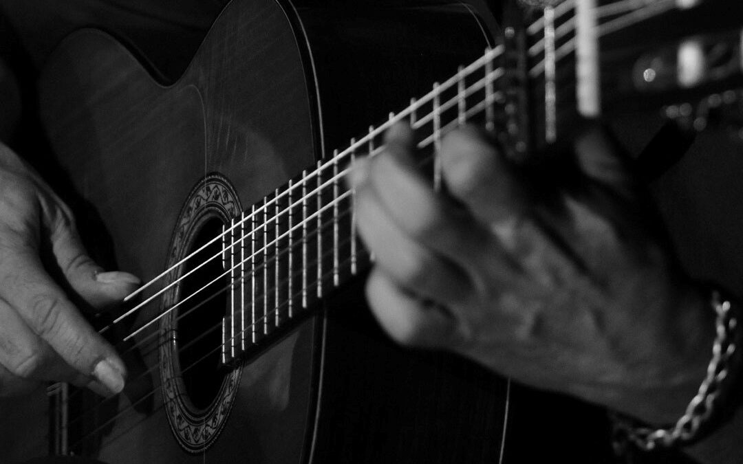 primer plano guitarrista tocando guitarra flamenca